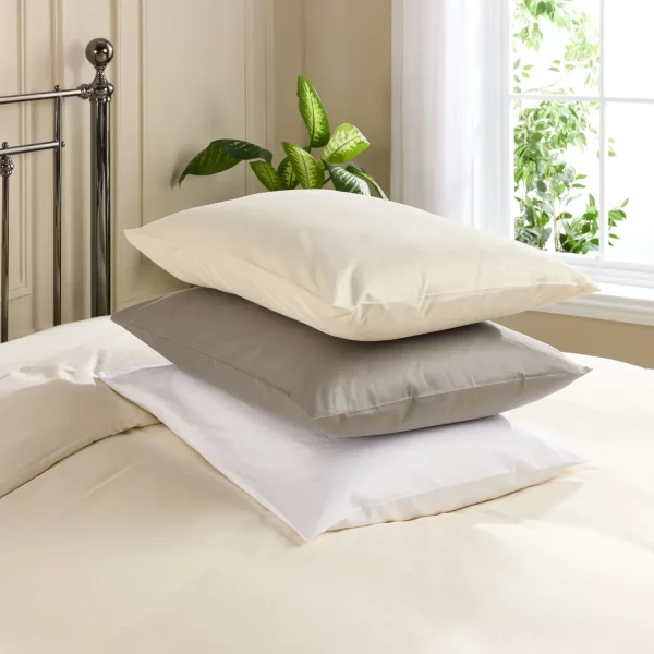 Three Hotel Pure Luxury classic pillowcases encasing pillows stacked on top of each other. In cream, grey and white.