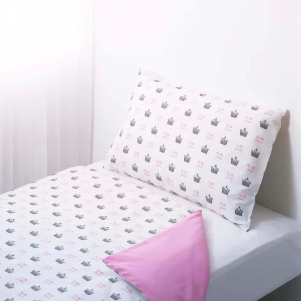 A white duvet cover and pillowcase. It features a print of small crowns all across it with pink writing that says 'My Little Princess'.