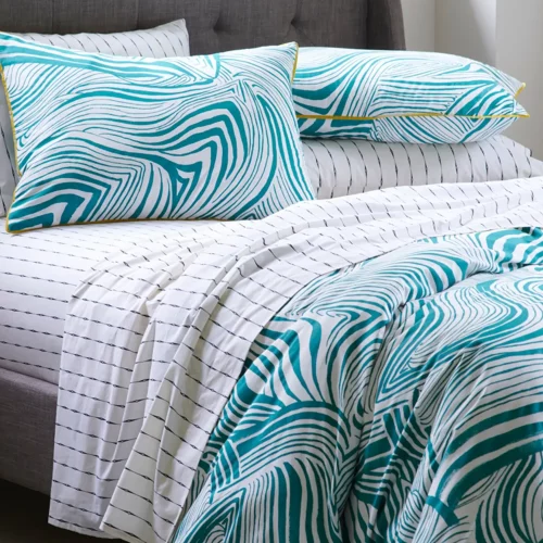 A green zebra marble patterned duvet cover and pillowcase set. There is also a vintage stripe fitted sheet visible.