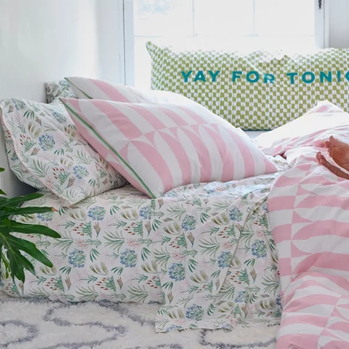 A waverly tile pink duvet cover and pillowcases. Also pictured is a green floral fitted sheet.