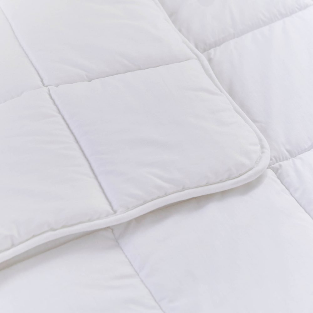 A close up look at a white anti-allergy 4 tog cot bed duvet from Martex Baby. The duvet has a square grid design.