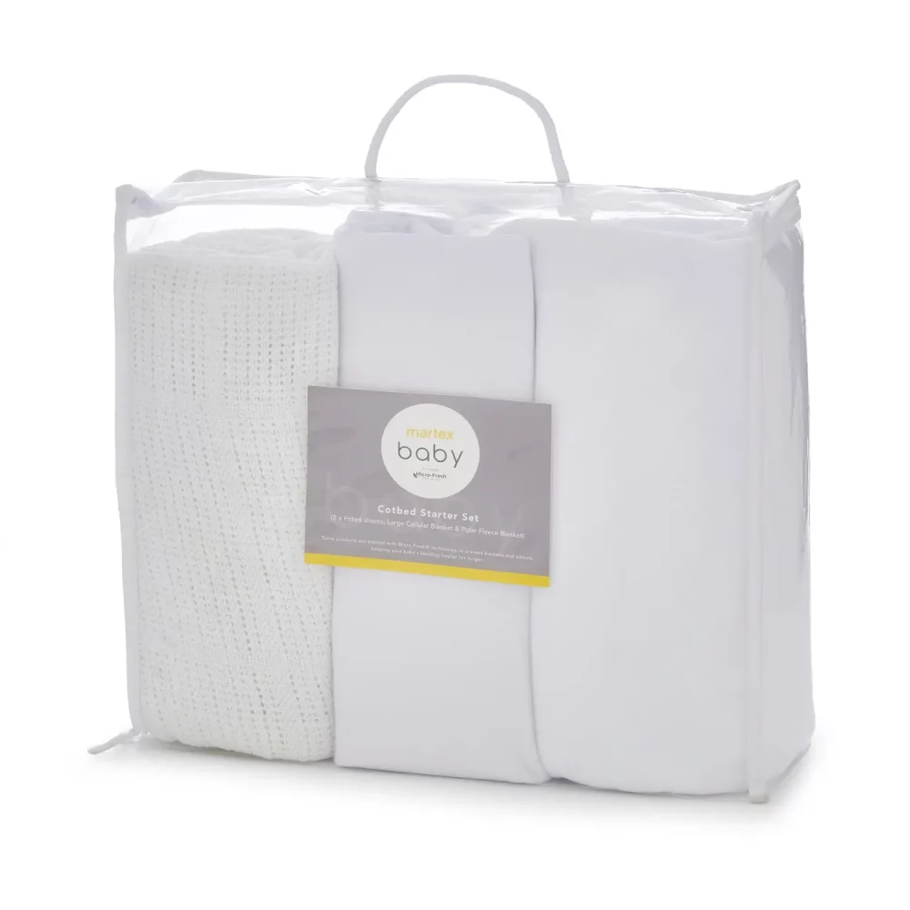 A Martex Baby white cot bed starter set in its packaging. It includes two fitted sheets, a polar fleece blanket and a cotton cellular blanket.