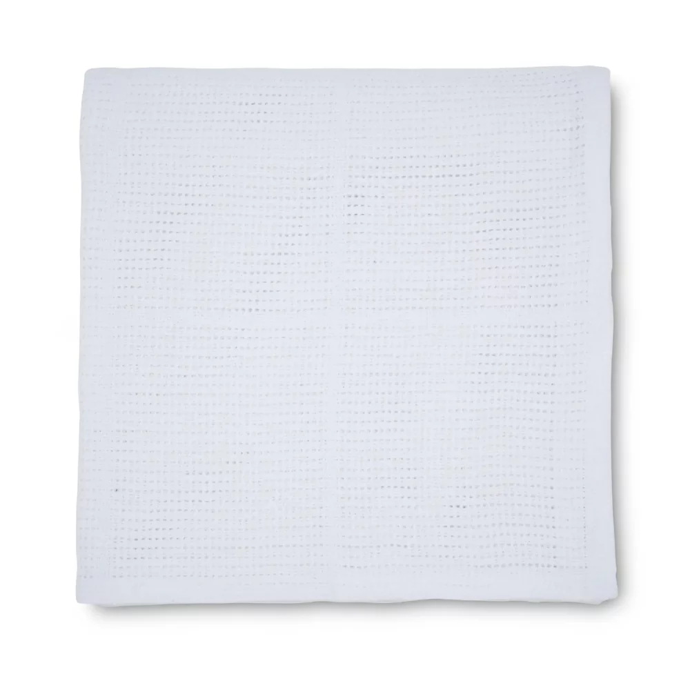 A Martex Baby white cellular blanket for use with babies.