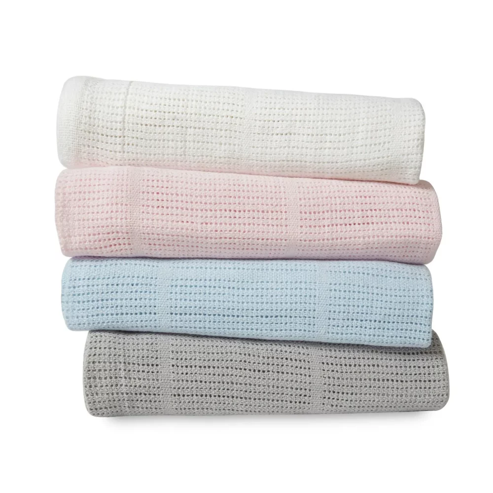 A stack of Clair De Lune cotton cellular blankets. It has a grey, blue, pink, and white blanket stacked on top of each other.