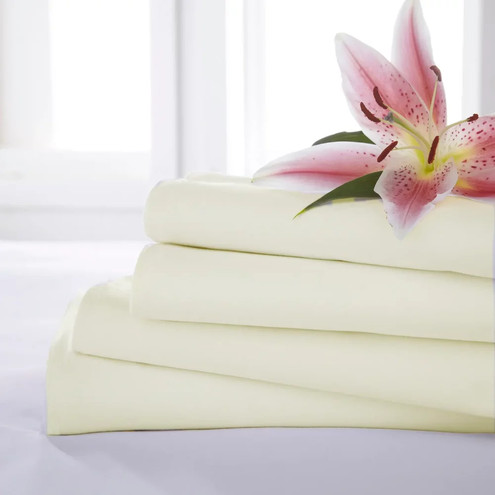 Close up of four Rich Cream Martex Percale Flat Sheets stacked on one another