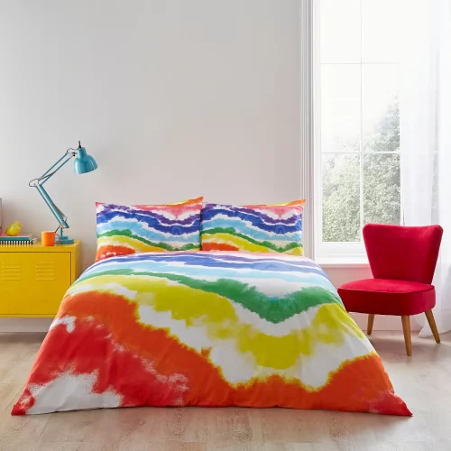 A multi-coloured rainbow Pride themed duvet cover and pillowcase set from Martex Pride covering a bed in a modern bedroom.